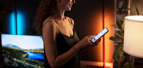 Mujer controlando la iluminación desde su smartphone - Grupo Versor