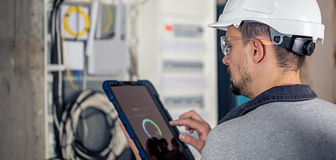 Técnico instalador revisando un tablero eléctrico con una tableta - Grupo Versor